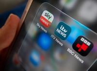 BATH, UNITED KINGDOM - NOVEMBER 08: A photo illustration of a man holding a phone, that shows ITV and Sky and BBC news apps on his phone screen on November 8, 2025 in Bath, England. ITV has said it is in the early stage of discussions to sell its broadcasting business to Sky in a move that could reshape the UK's linear television landscape as it continues to come under increased competition from streaming services. (Photo by Anna Barclay/Getty Images)