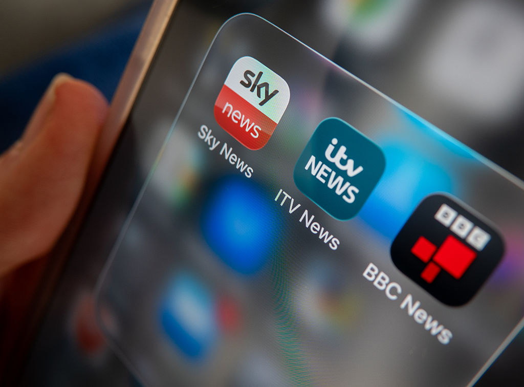 BATH, UNITED KINGDOM - NOVEMBER 08: A photo illustration of a man holding a phone, that shows ITV and Sky and BBC news apps on his phone screen on November 8, 2025 in Bath, England. ITV has said it is in the early stage of discussions to sell its broadcasting business to Sky in a move that could reshape the UK's linear television landscape as it continues to come under increased competition from streaming services. (Photo by Anna Barclay/Getty Images)