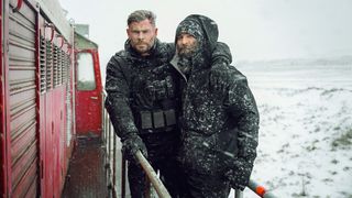 Christ Hemsworth and Sam Hargrave standing on a train in a snowstorm