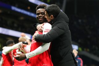 Mikel Arteta, manager of Arsenal, embraces Bukayo Saka of Arsenal after the Premier League match between Tottenham Hotspur and Arsenal FC at Tottenham Hotspur Stadium on January 15, 2023 in London, England.