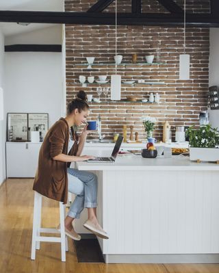 Woman on Laptop Sitting in Kitchen