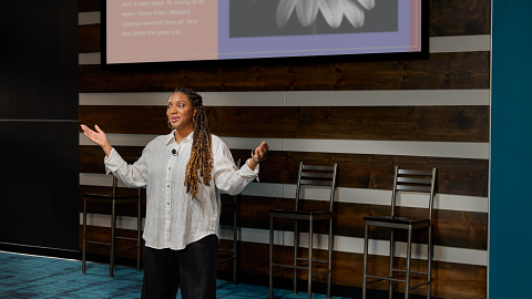 A woman presenting a speech wearing the Shure WL18Xm mic.