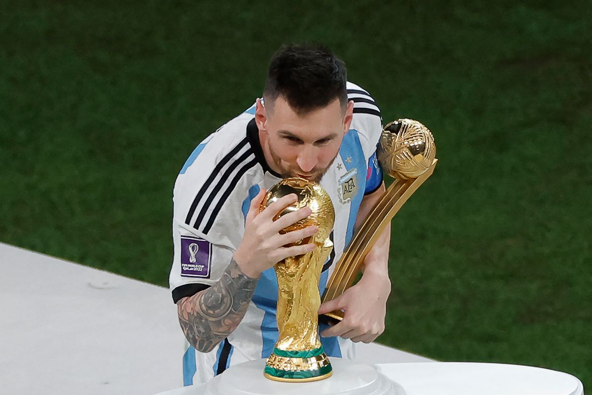 Lionel Messi kisses the World Cup trophy after Argentina&#039;s win over France in Qatar.