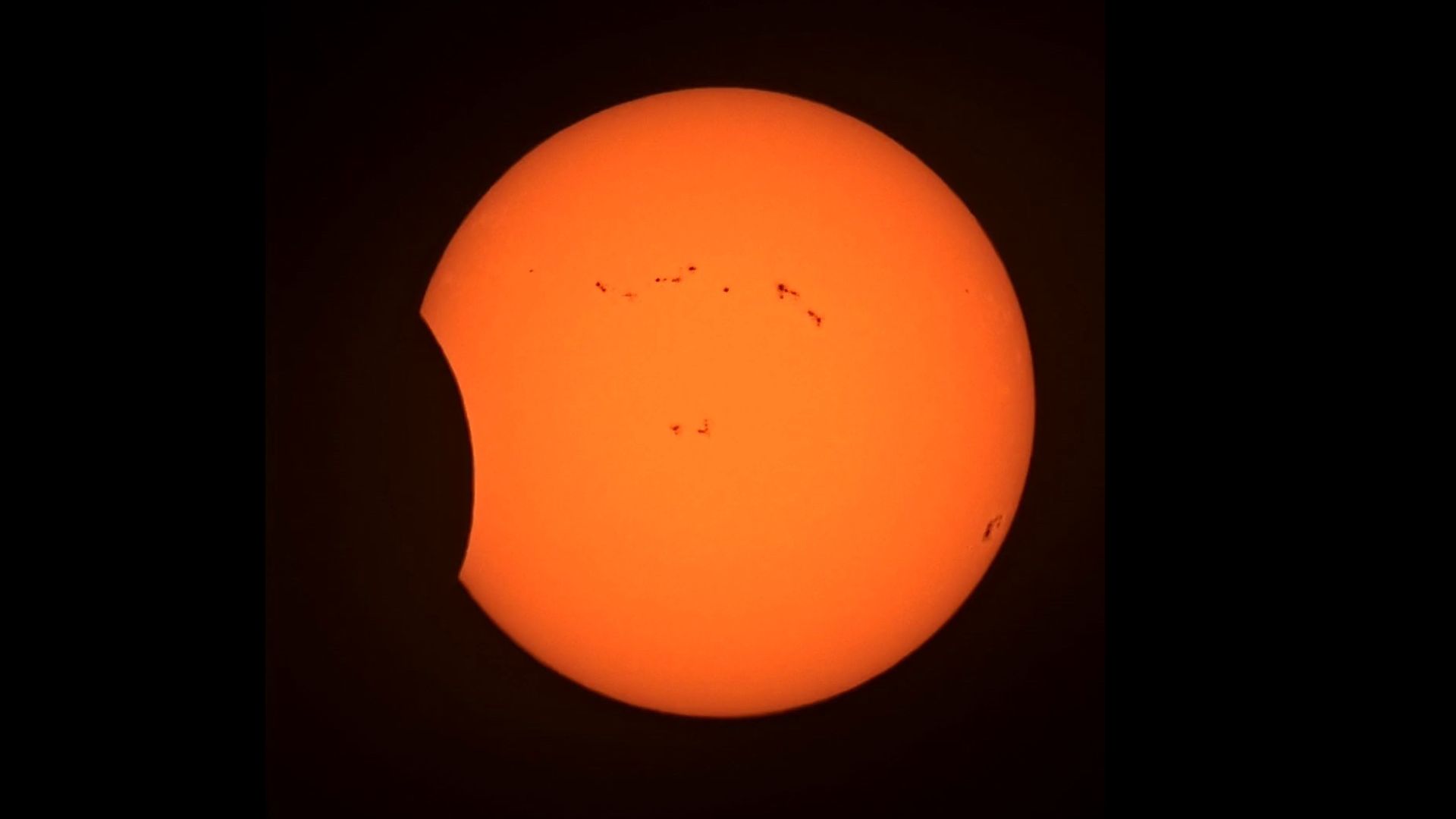 a partially eclipsed sun with the moon appearing to the left