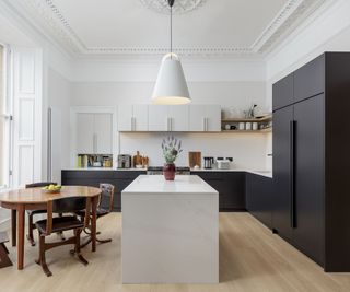 Two-tone kitchen with black lower cabinets and white island and upper cabinets