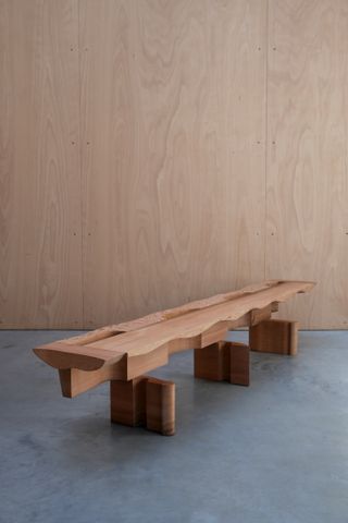 A wooden bench by Max Lamb, composed like puzzles with pieces of wood cut from the same block