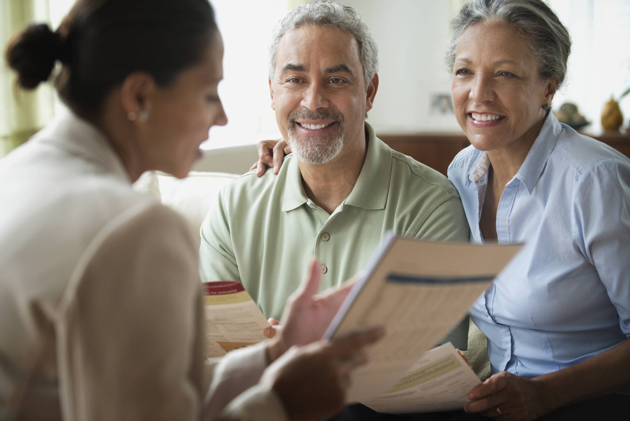 A financial adviser discusses finances with a senior couple.