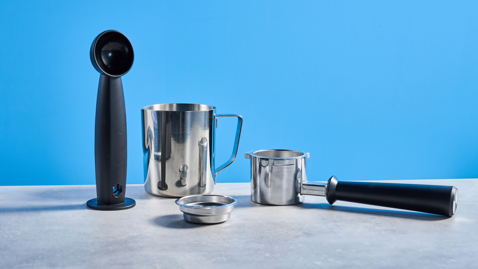 The Cuisinart Espresso Bar Slim espresso machine on a stone surface with a blue background