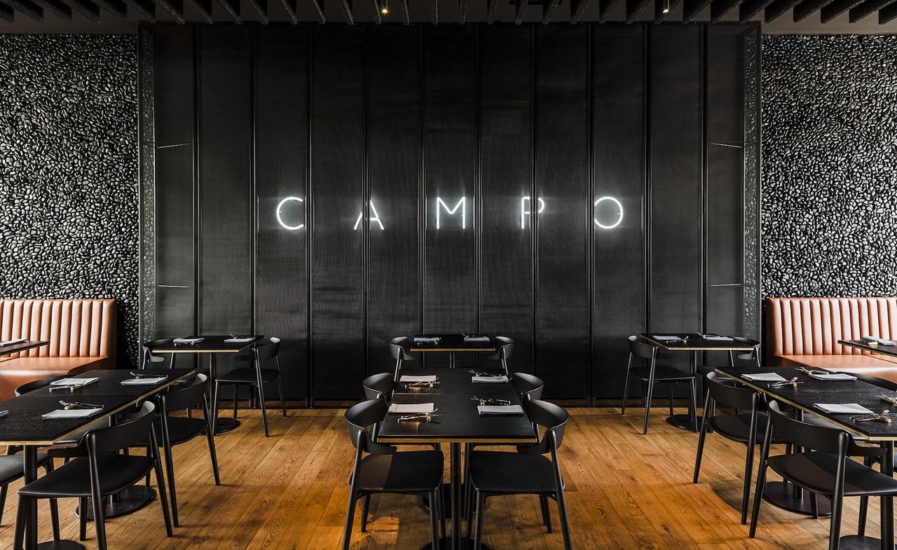 Campo Restaurant in Poland with black walls, table and chairs with wooden floors