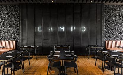 Campo Restaurant in Poland with black walls, table and chairs with wooden floors