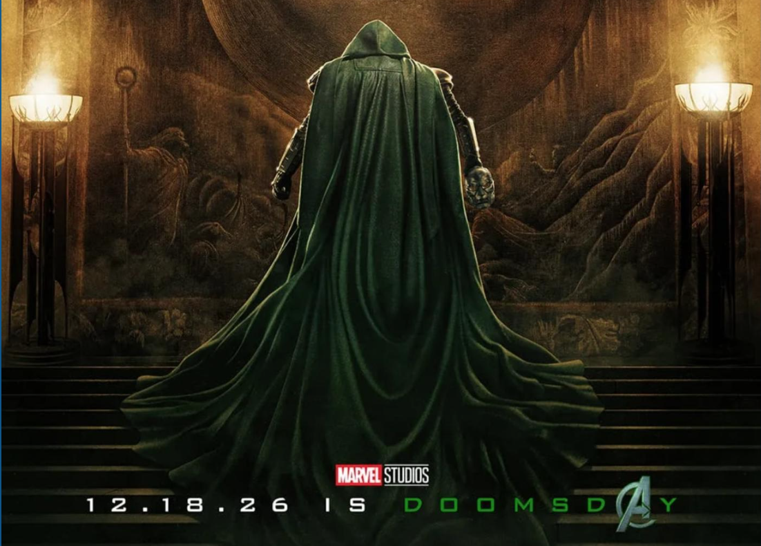 A villain wearing a green cape shows off a movie promo poster