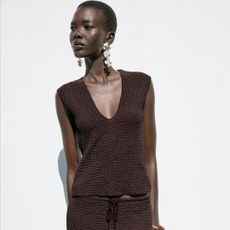 A zara model wears brown Textured V-Neck Top on grey background