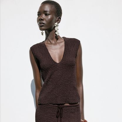 A zara model wears brown Textured V-Neck Top on grey background 