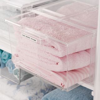 Pink towels in a transparent plastic storage box