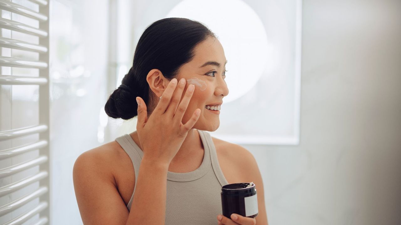 Rosalique - woman applying cream to her cheeks