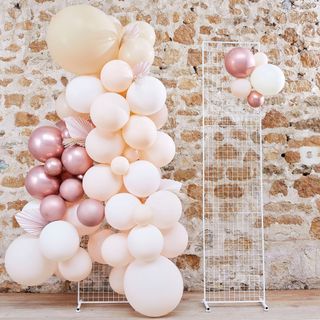 pink stone wall with pink balloons on white metal stand