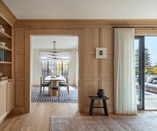 View from a wood panelled hallway into a dining room