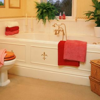 bathroom with white bathtub and red throws