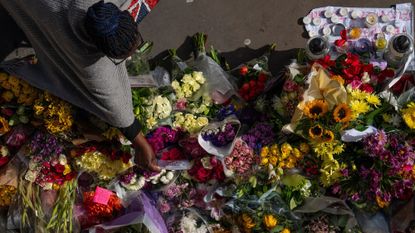 A woman lays flowers at the scene of Elianne Andam&#039;s murder in Croydon