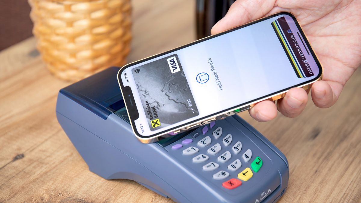 iPhone paying for something using Apple Pay at a card reader