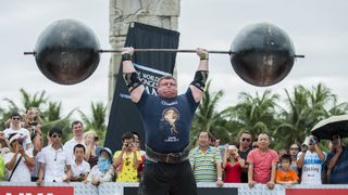 Zydrunas Savickas of Lithuania lifts a giant black bar bell at the Circus Medley event ahead of the World's Strongest Man 2025 competition