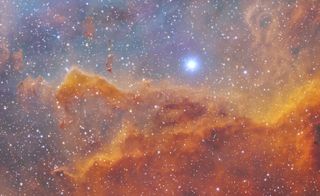 A rusty orange cloud of gas and dust lies below a bright blue star.