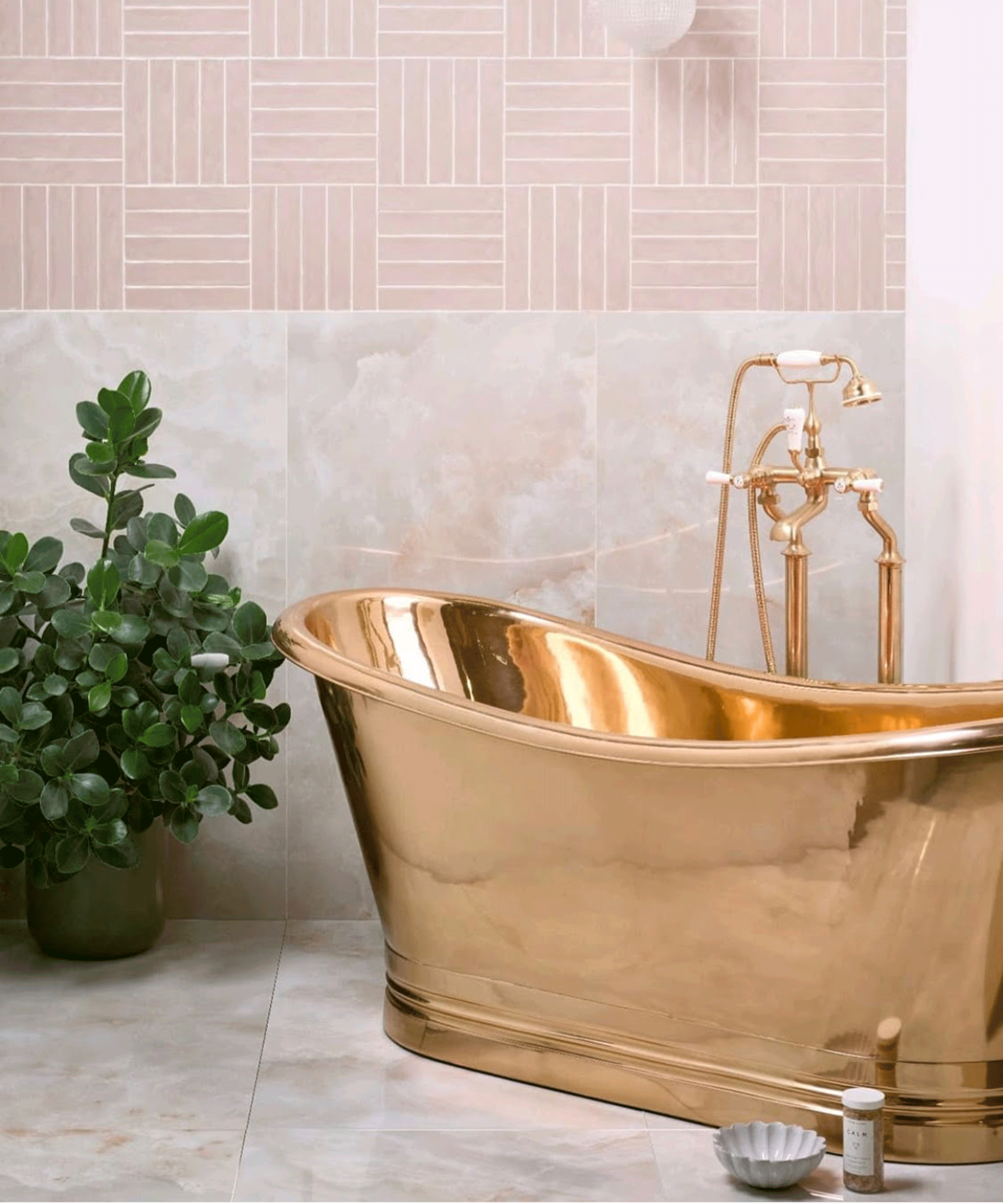A copper boat bath in bathroom with pink tiles