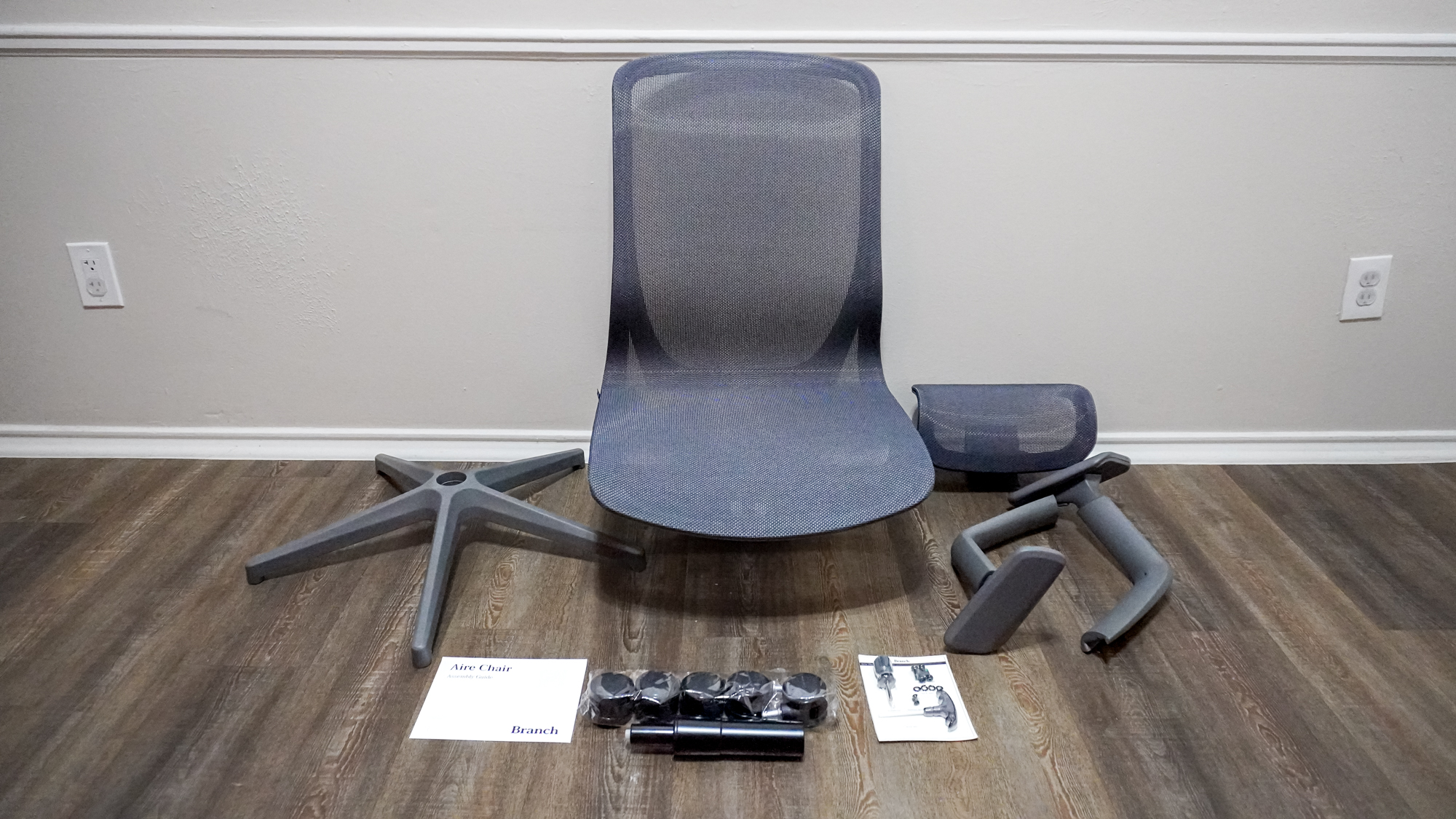 The Branch Aire Chair unboxed with all of its parts laid out on the floor
