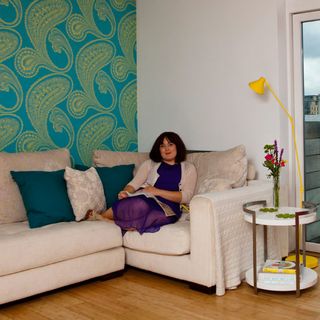 living room with wallpaper on wall and sofa with cushions