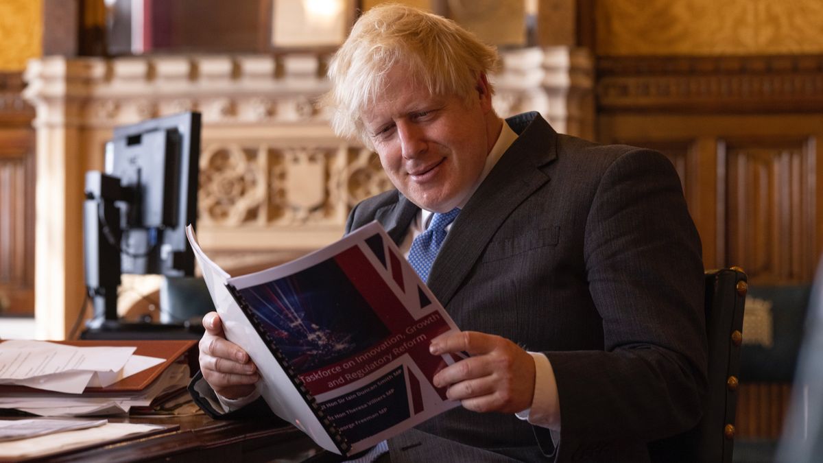 Boris Johnson reading the report prepared by a special taskforce of Conservative MPs