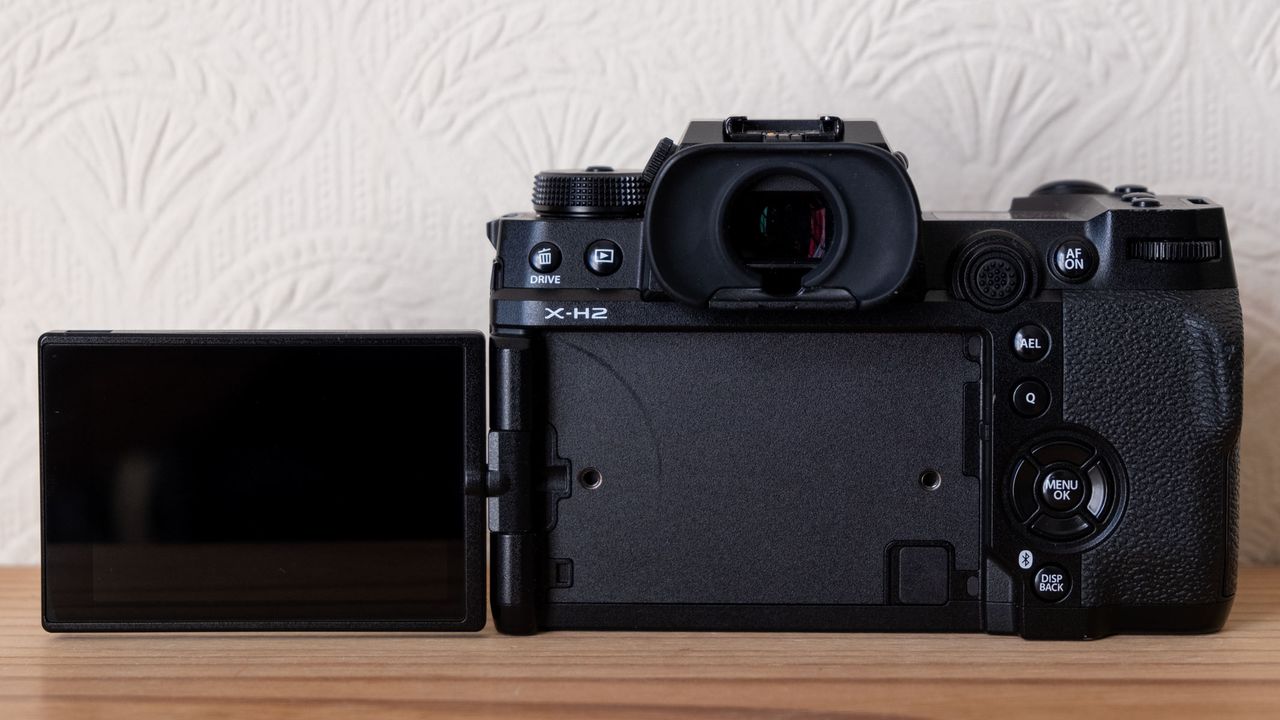 The Fujifilm X-H2 from the back with screen flipped out to the left.