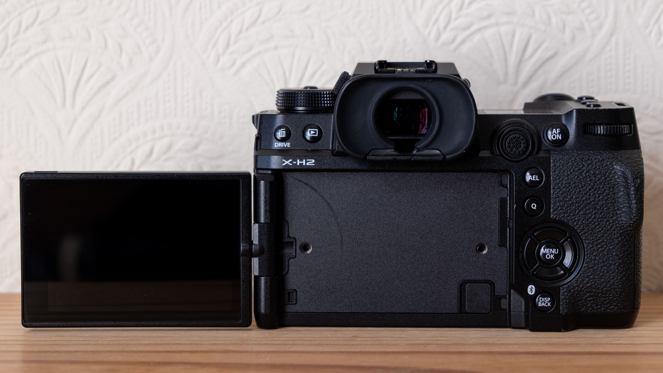 The Fujifilm X-H2 from the back with screen flipped out to the left.