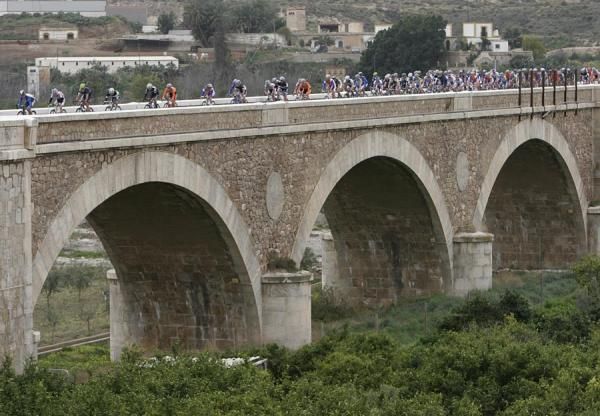 The Clasica de Almeria peloton negotiates a bridge.