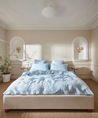 Coast Bedding Bundle on a bed against beige walls; in the back corner, a potted plant.