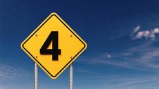 Number 4 written yellow on road traffic sign before blue sky.