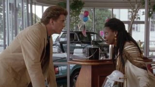 Ted Danson and Whoopi Goldberg speaking in a car dealership in Made in America