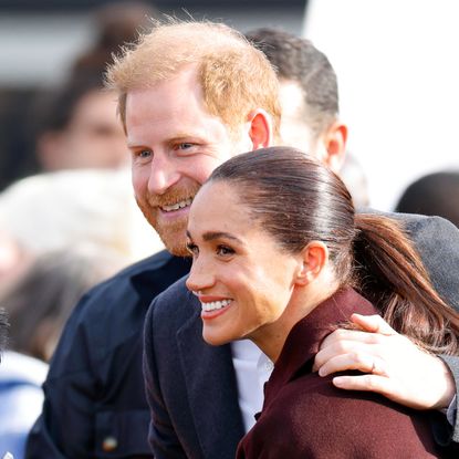 Prince Harry and Meghan Markle smiling for a picture with fans in Nottingham, England