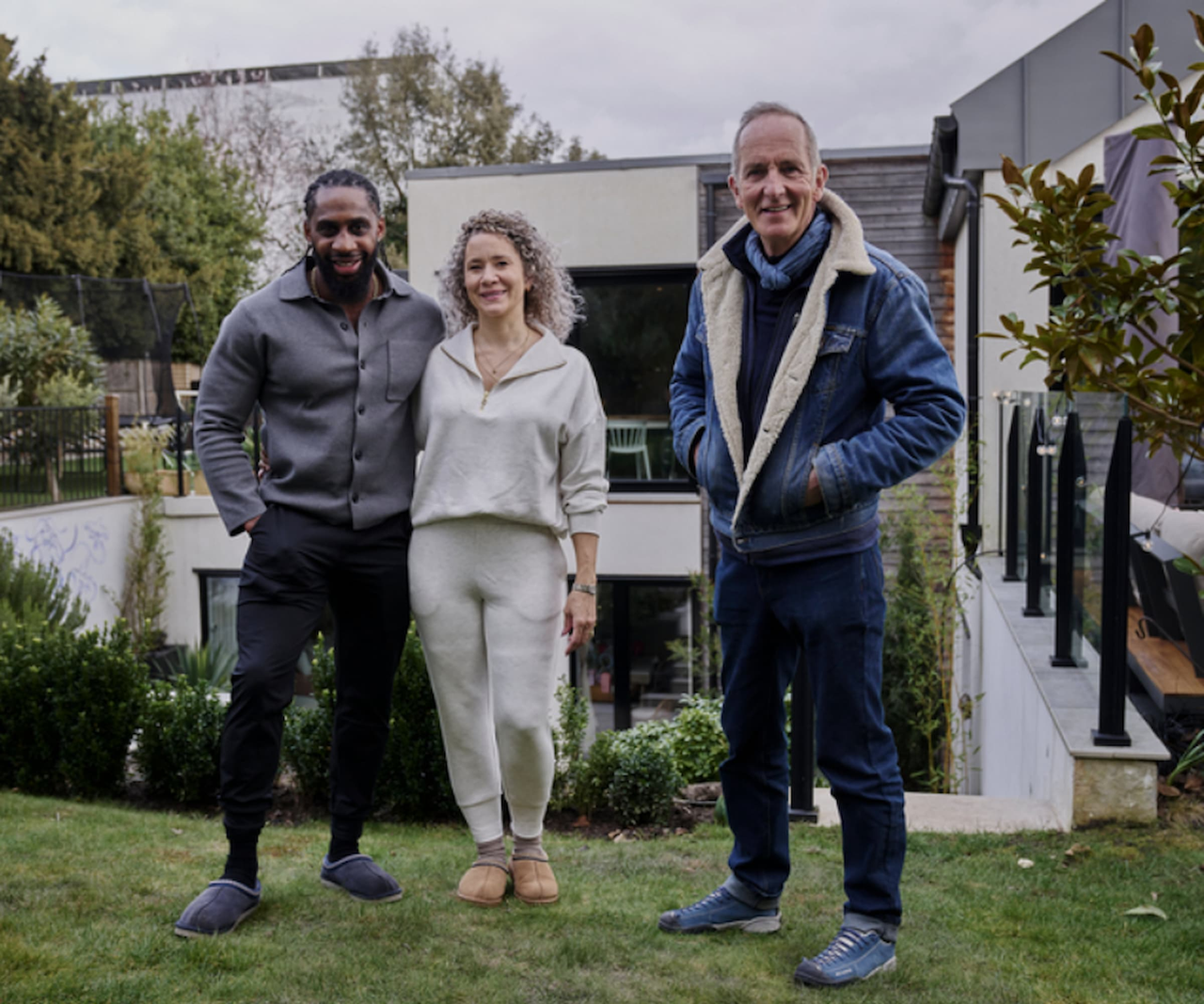 Kevin McCloud with two homeowners in the back of a garden