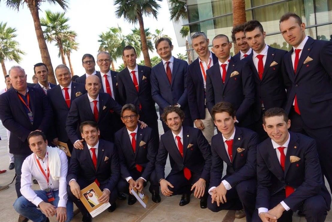 Riders and staff pose for a photo outside