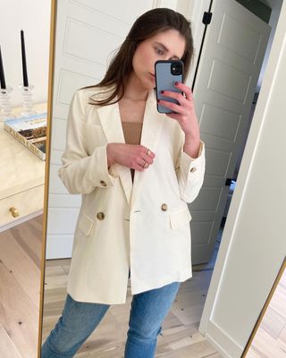 @allypayer wearing a cream blazer and blue jeans