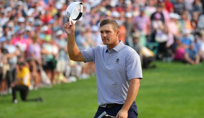 DeChambeau waves to the crowd with his hat in hand