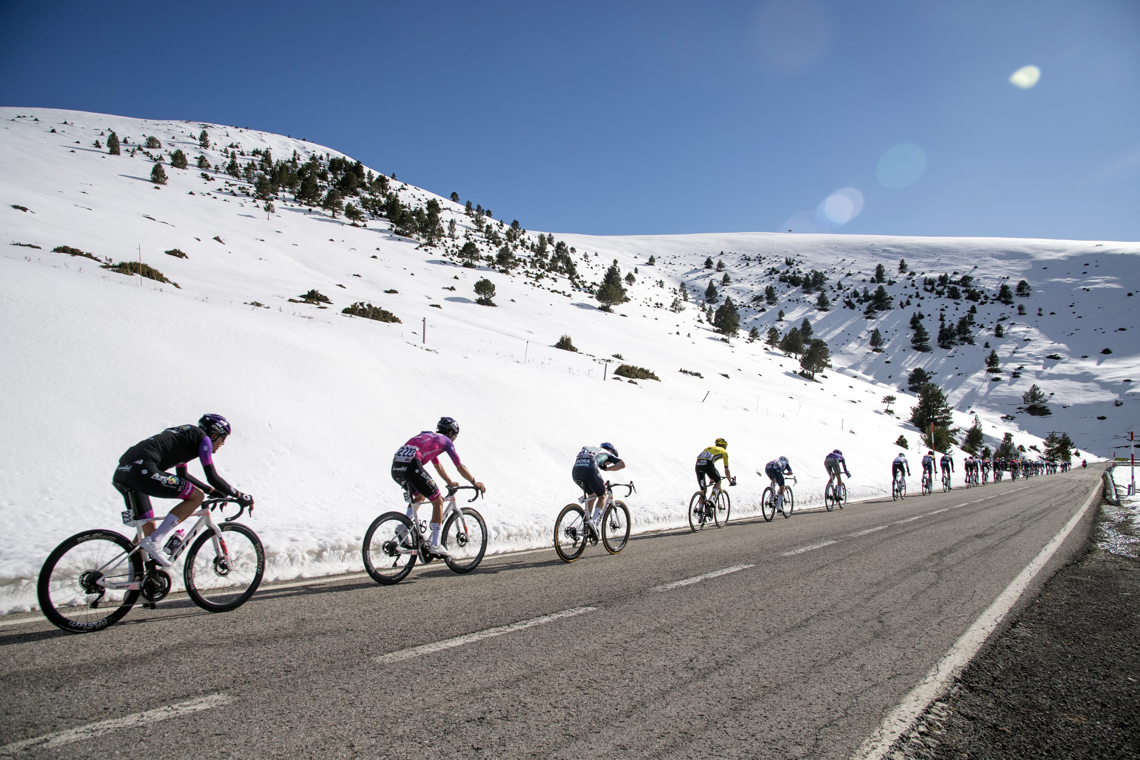 Riders traverse snow flanked hills in Volta Catalunya 2025