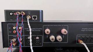 Streaming amp and wireless streamer on black table with cables connecting them