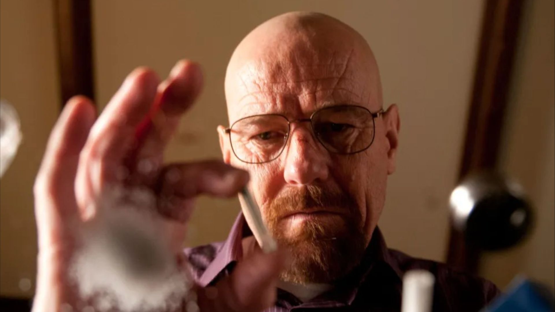 Walter White looking at an unknown substance on a glass table in Breaking Bad
