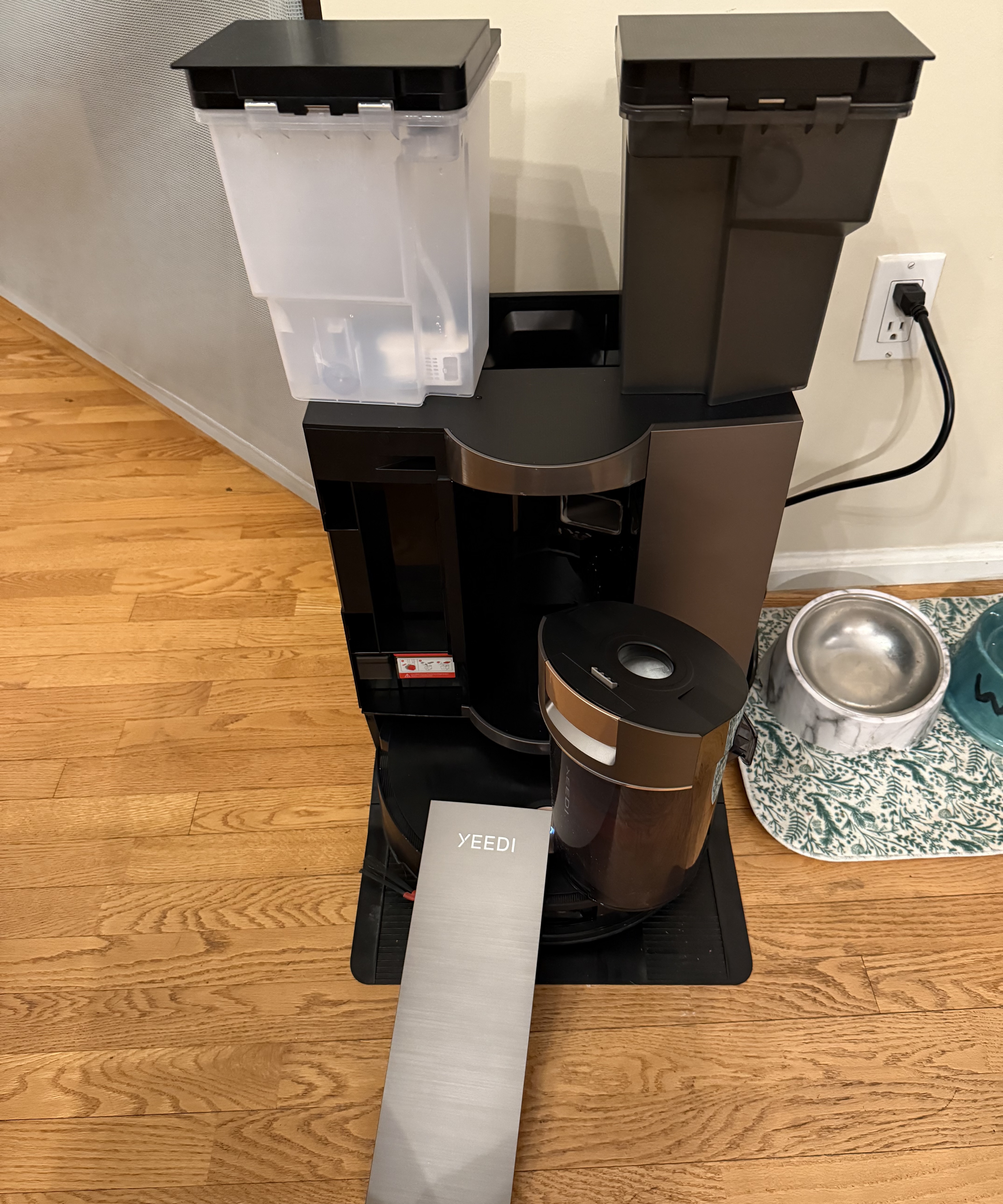 Yeedi S20 Infinity base station with clean and dirty water tanks along with dustbin removed and visible. Side panel removed to show cleaning solution reservoirs.