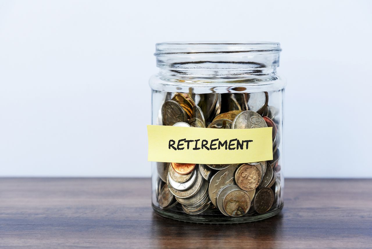 Coins in a glass jar that is labeled &quot;RETIREMENT&quot;