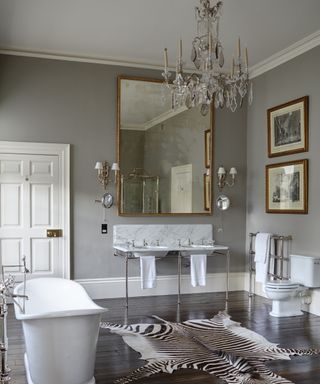 A grey bathroom with crystal chandelier and animal rug