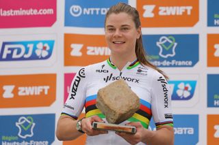 Team SD Worx - Protime's Belgian rider Lotte Kopecky celebrates on the podium with the cobblestone trophy after winning the fourth edition of the women's Paris-Roubaix one-day classic cycling race, 148,5km between Denain and Roubaix, on April 6, 2024. (Photo by Thomas SAMSON / AFP)
