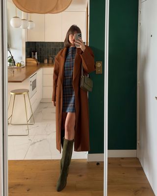 @juliesfi wearing a tartan mini dress, suede boots and a long coat