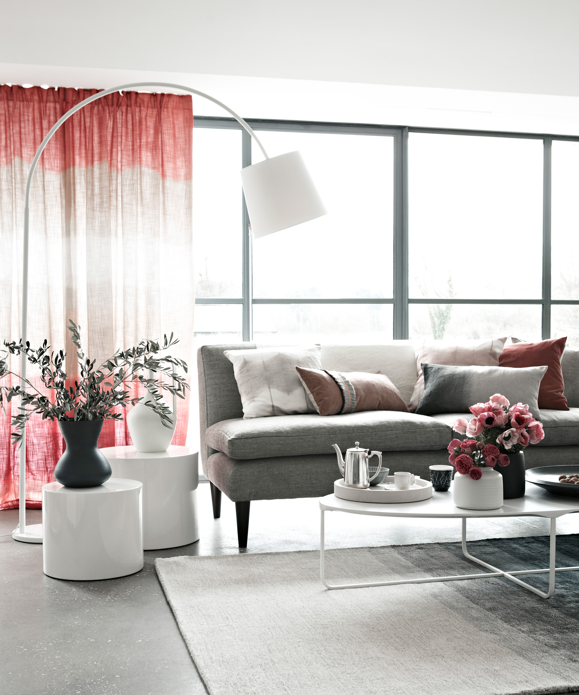 Grey living room ideas illustrated in a pale grey scheme with white coffee tables and pink drapes.